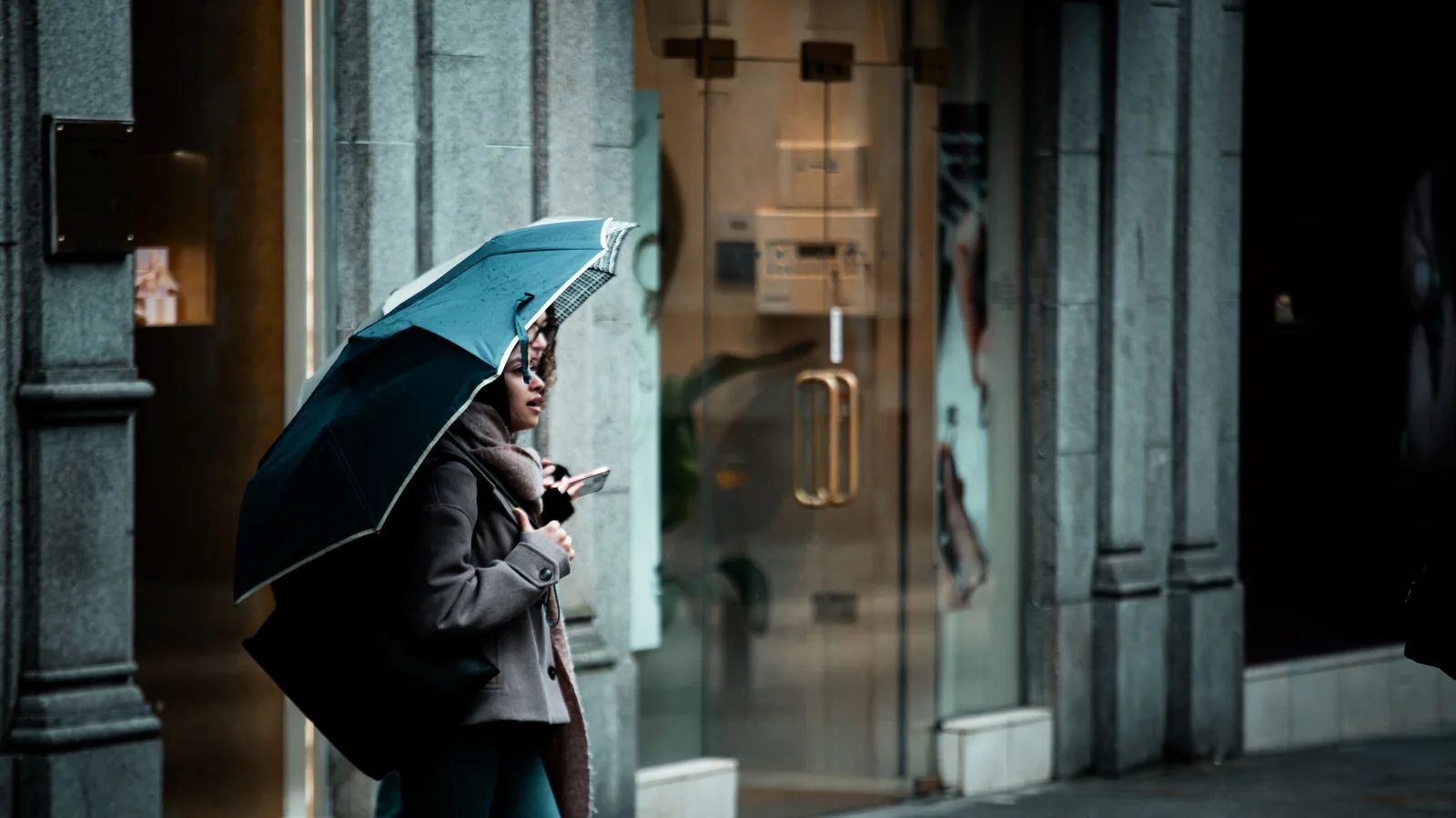 Parapluie plié près d'un sac et d'un manteau